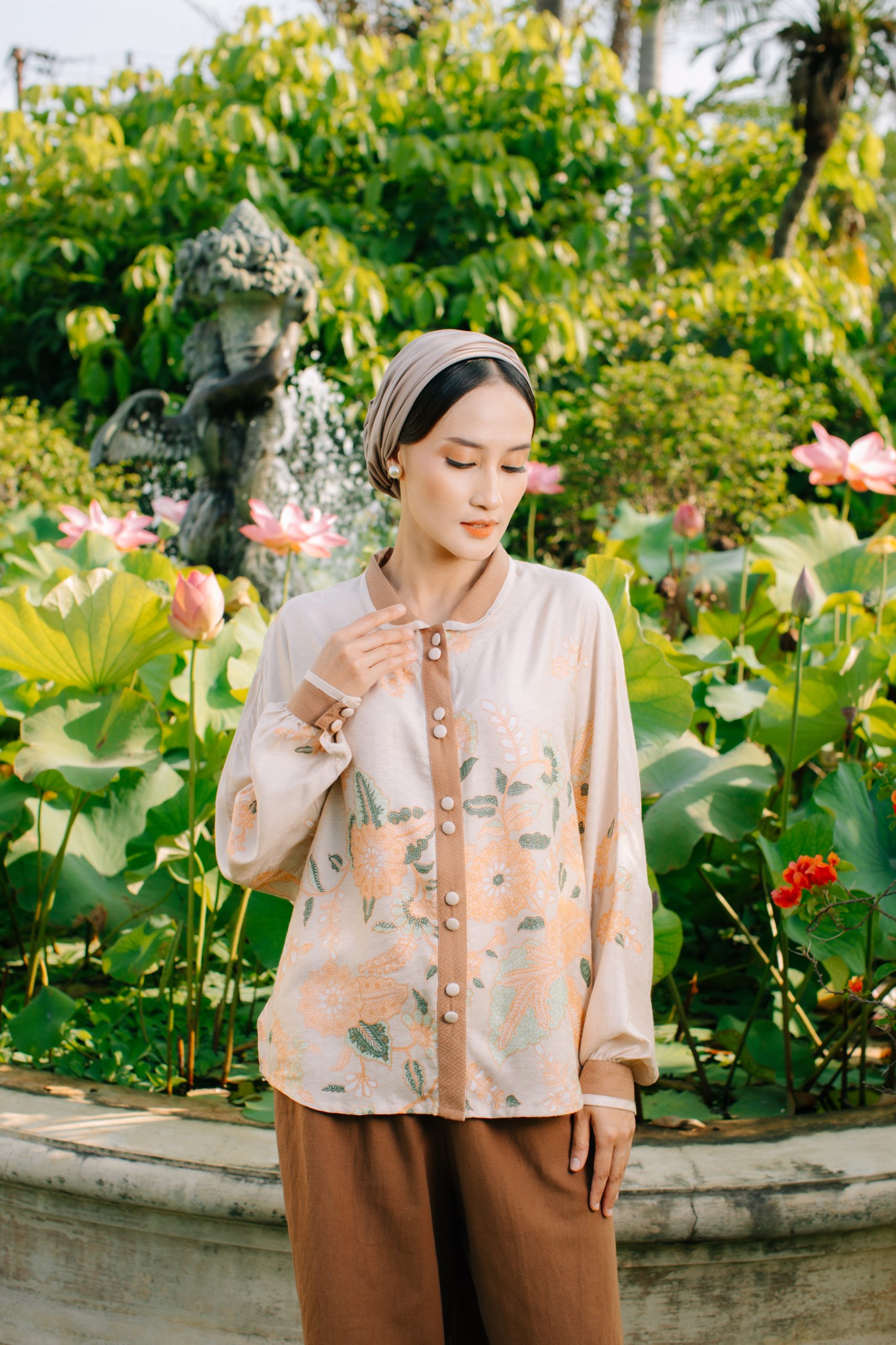 Model mengenakan koleksi Blooming Raya Series dari Batik Iskandartex dengan motif floral elegan di taman