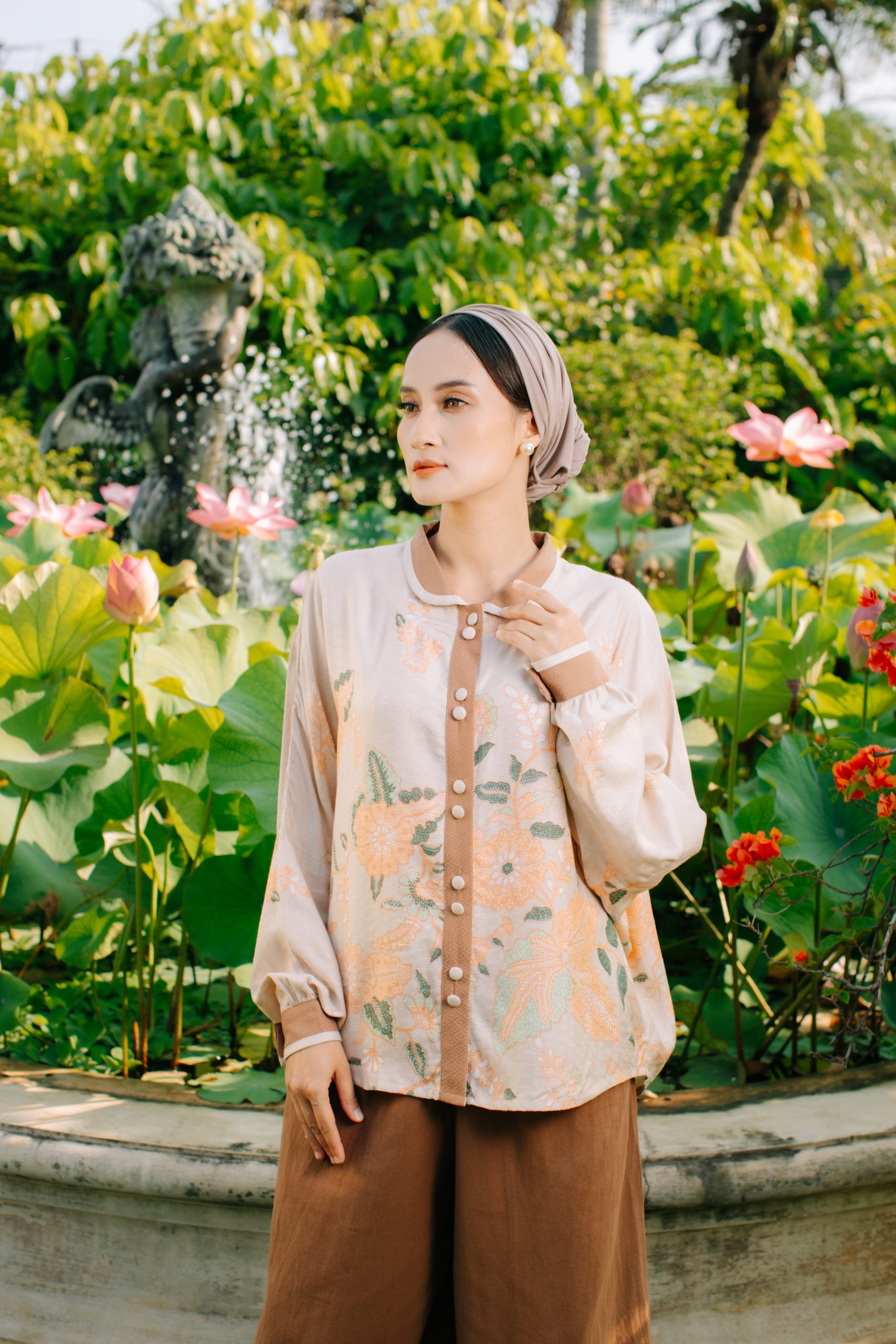 Model mengenakan koleksi Blooming Raya Series dari Batik Iskandartex dengan motif floral elegan di taman