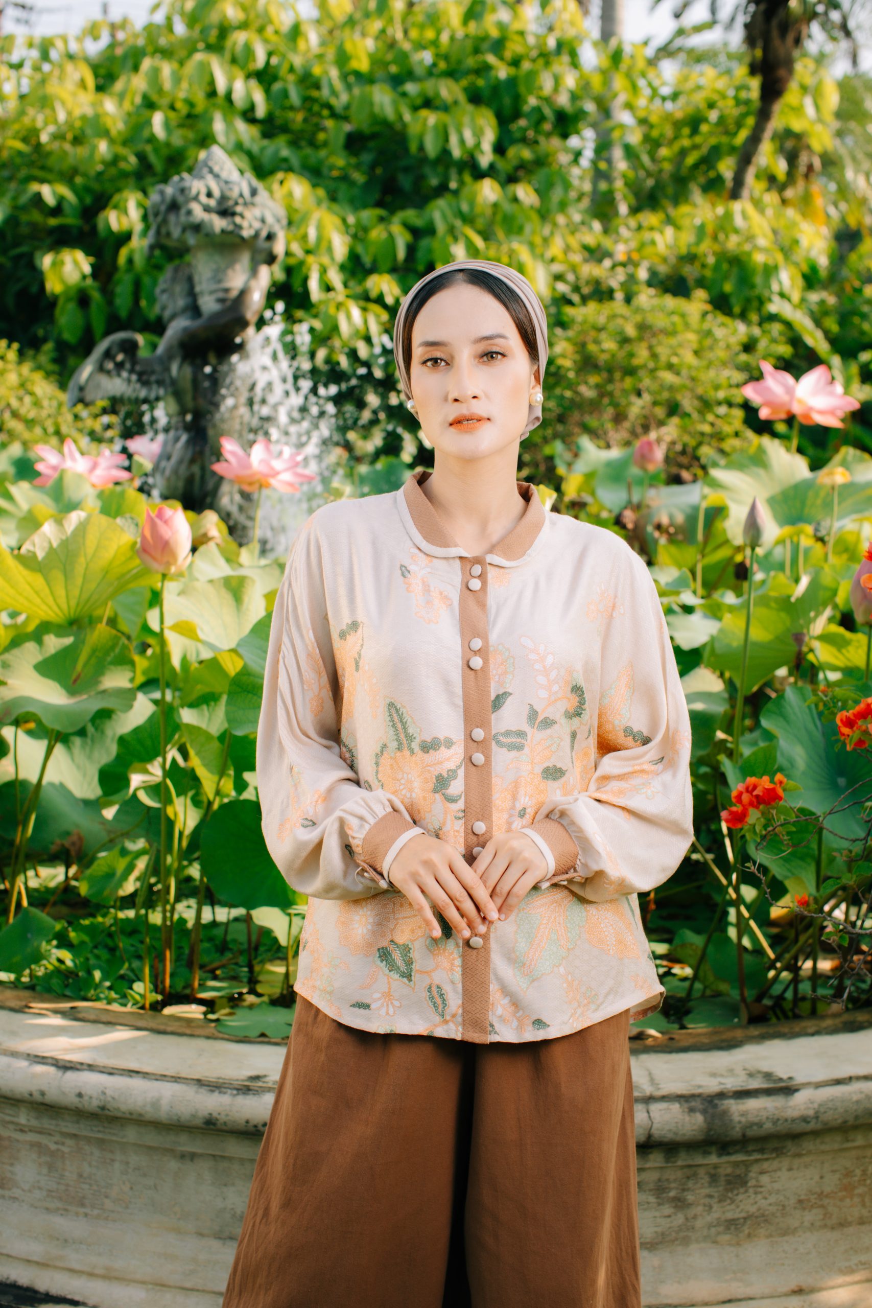 Model mengenakan koleksi Blooming Raya Series dari Batik Iskandartex dengan motif floral elegan di taman