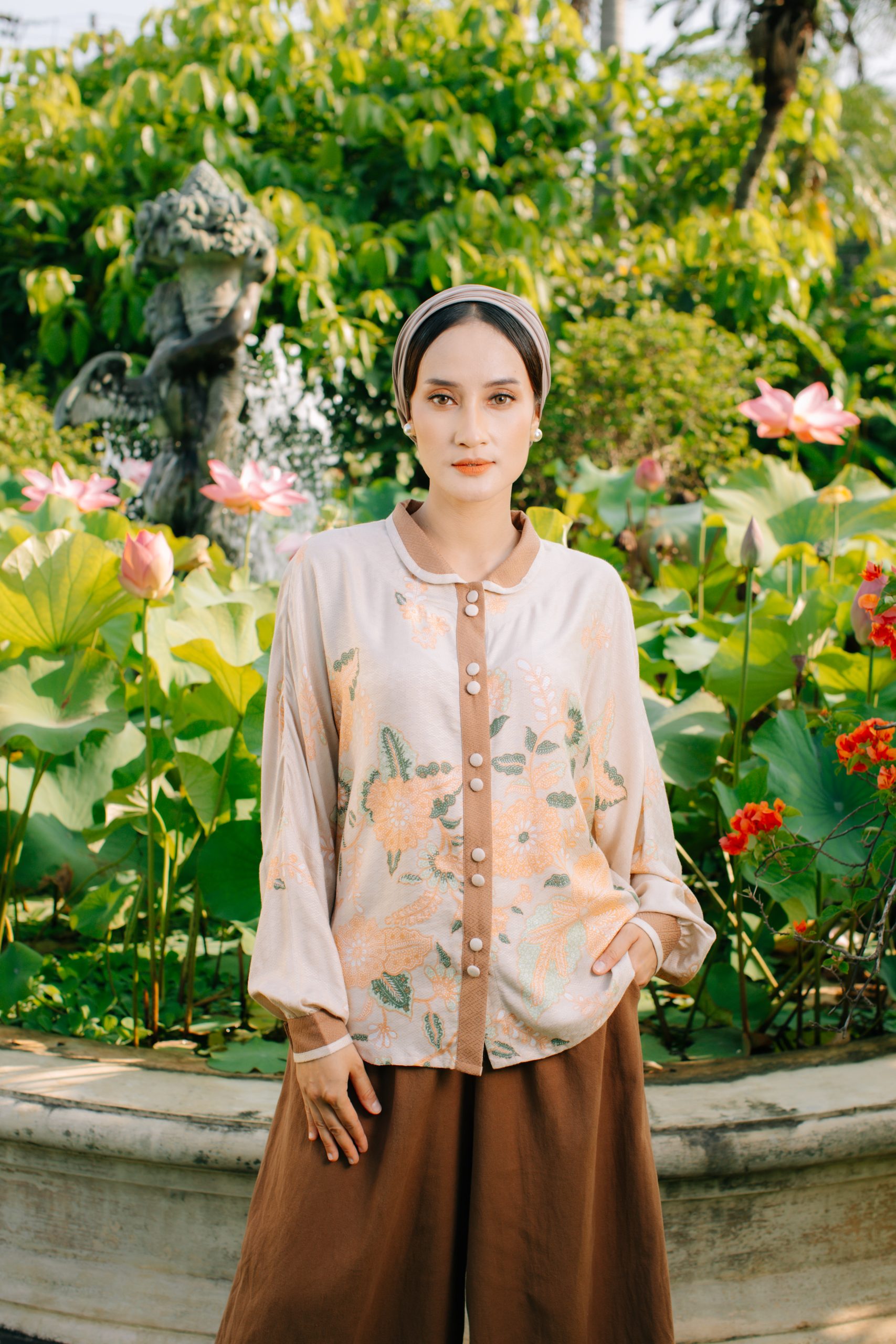 Model mengenakan koleksi Blooming Raya Series dari Batik Iskandartex dengan motif floral elegan di taman