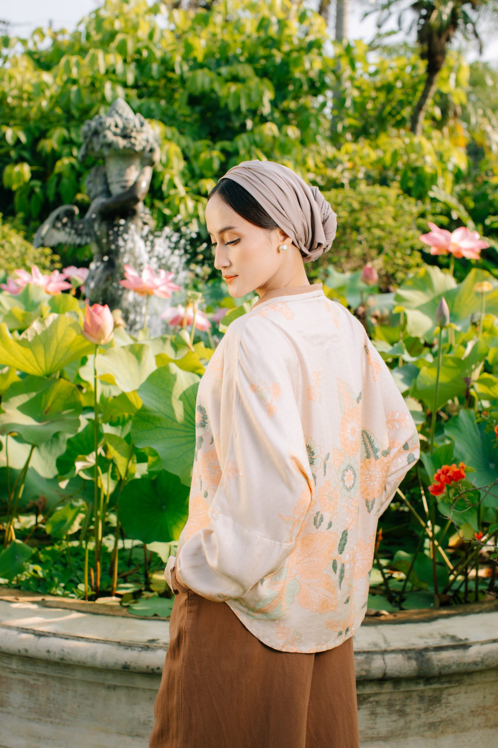 Model mengenakan koleksi Blooming Raya Series dari Batik Iskandartex dengan motif floral elegan di taman