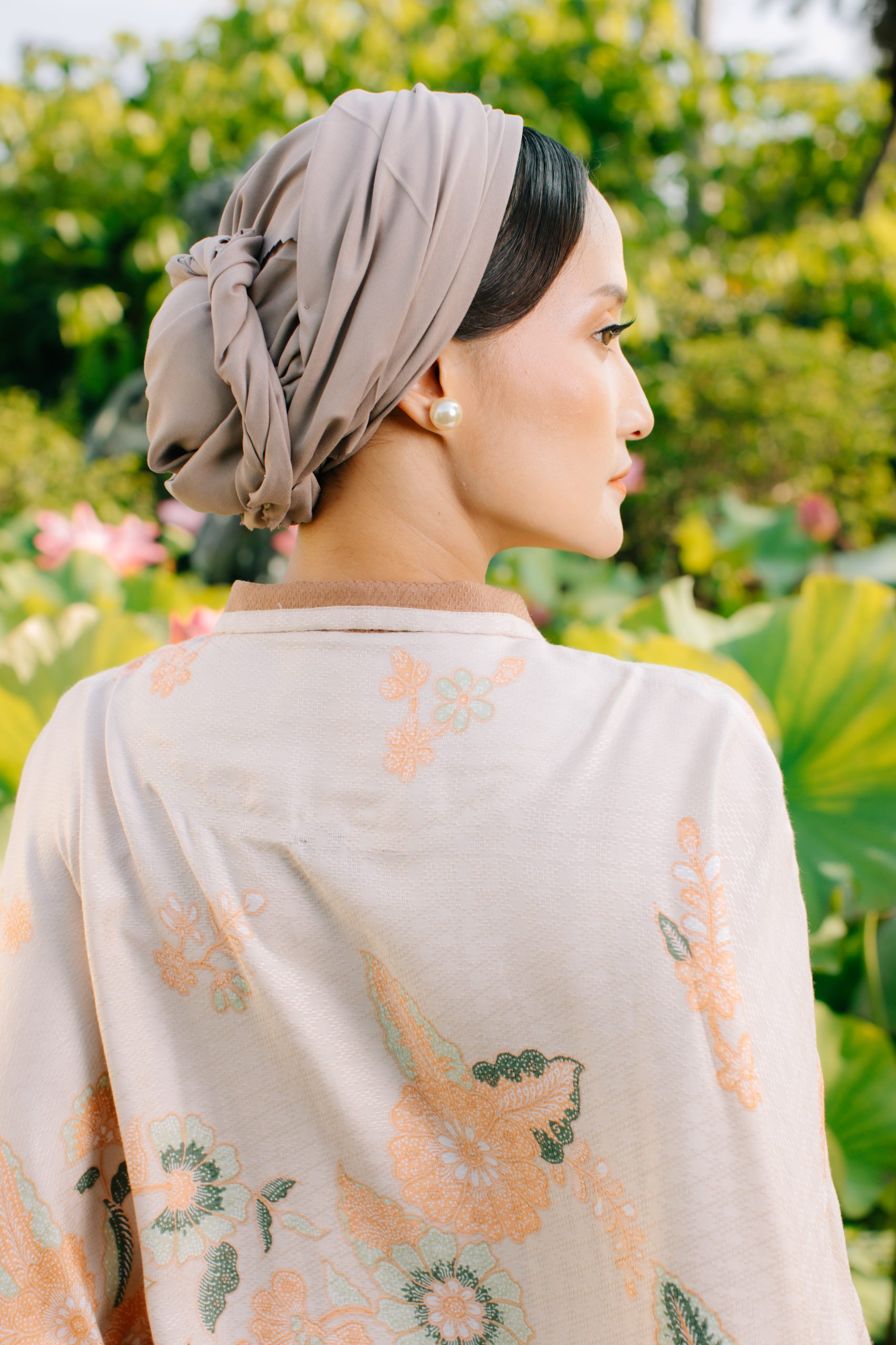 Model mengenakan koleksi Blooming Raya Series dari Batik Iskandartex dengan motif floral elegan di taman