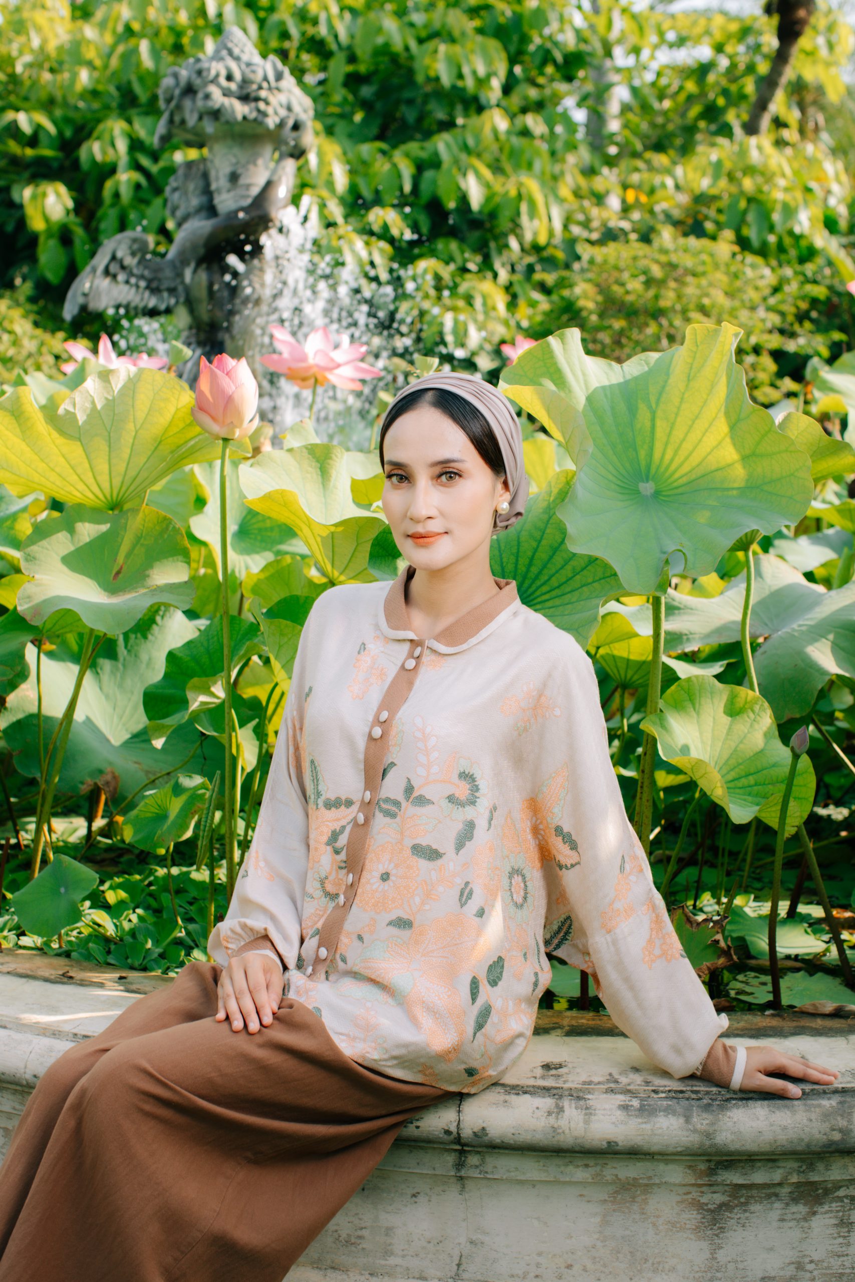 Model mengenakan koleksi Blooming Raya Series dari Batik Iskandartex dengan motif floral elegan di taman