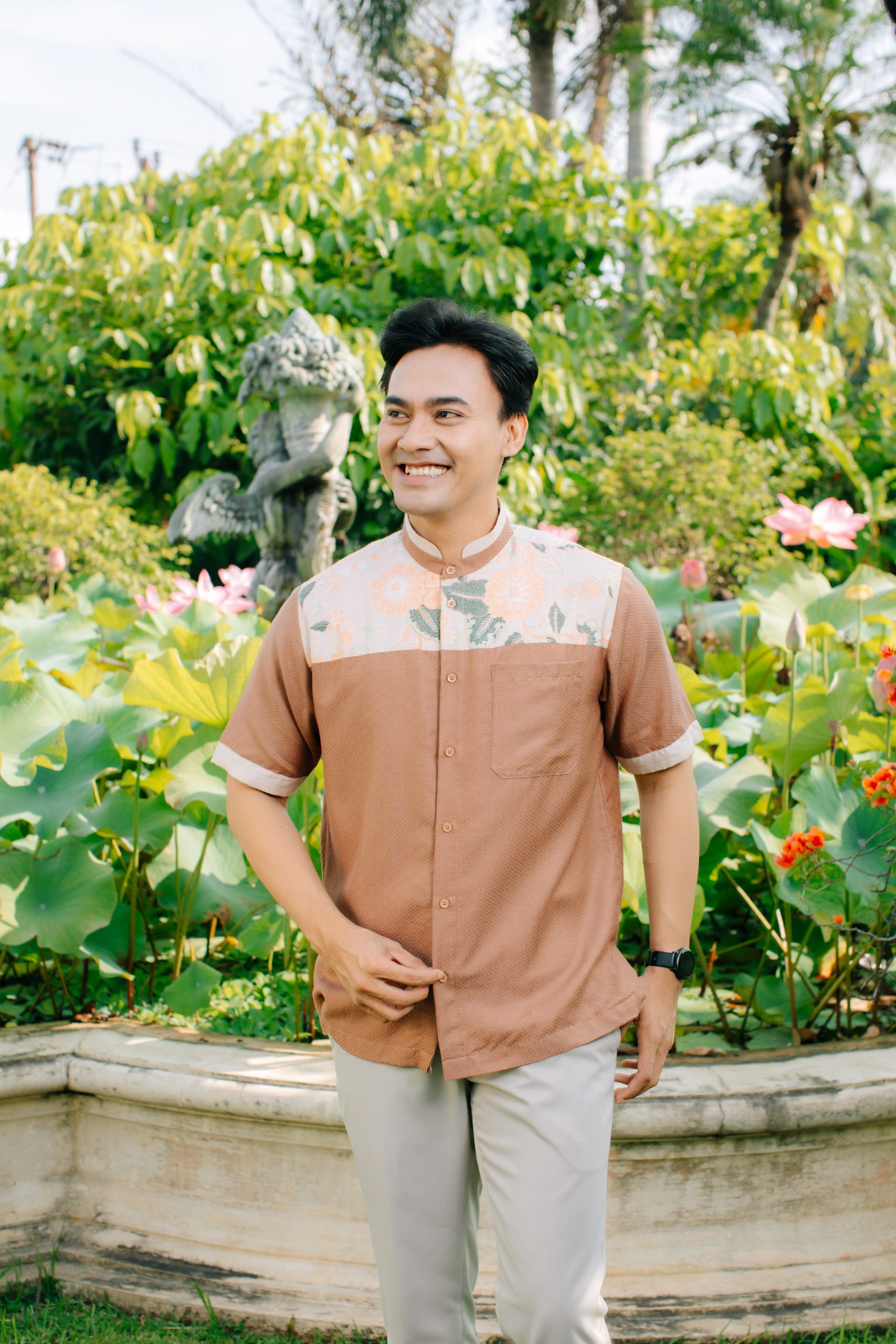 Model mengenakan koleksi Blooming Raya Series dari Batik Iskandartex dengan motif floral elegan di taman