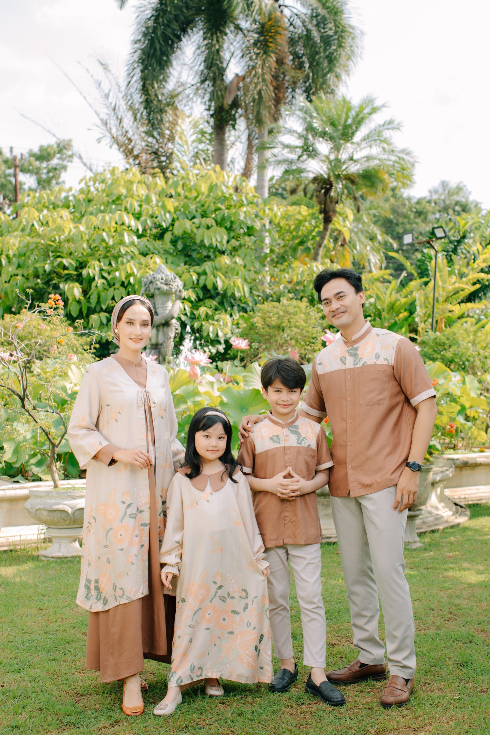 Model mengenakan koleksi Blooming Raya Series dari Batik Iskandartex dengan motif floral elegan di taman