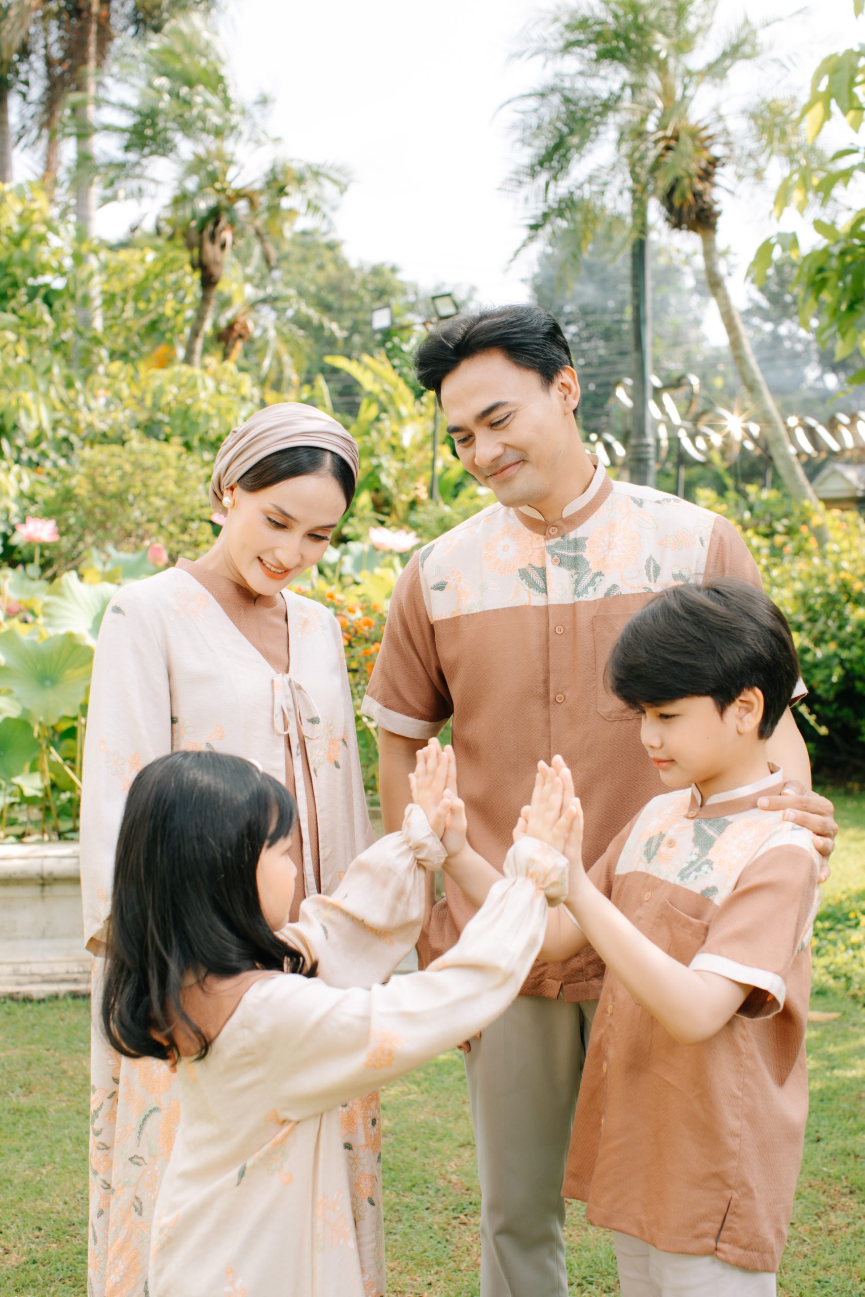 Model mengenakan koleksi Blooming Raya Series dari Batik Iskandartex dengan motif floral elegan di taman