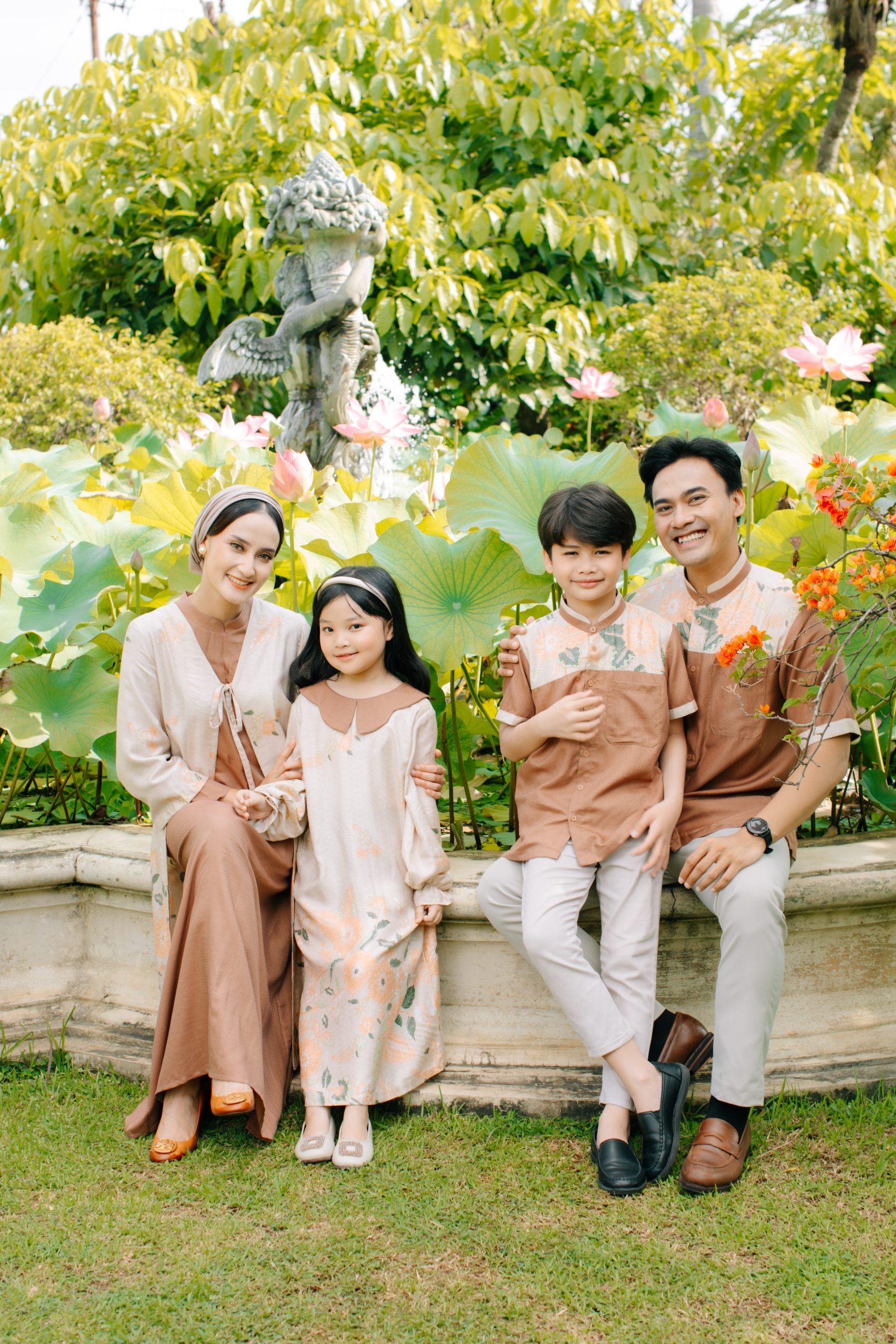 Model mengenakan koleksi Blooming Raya Series dari Batik Iskandartex dengan motif floral elegan di taman