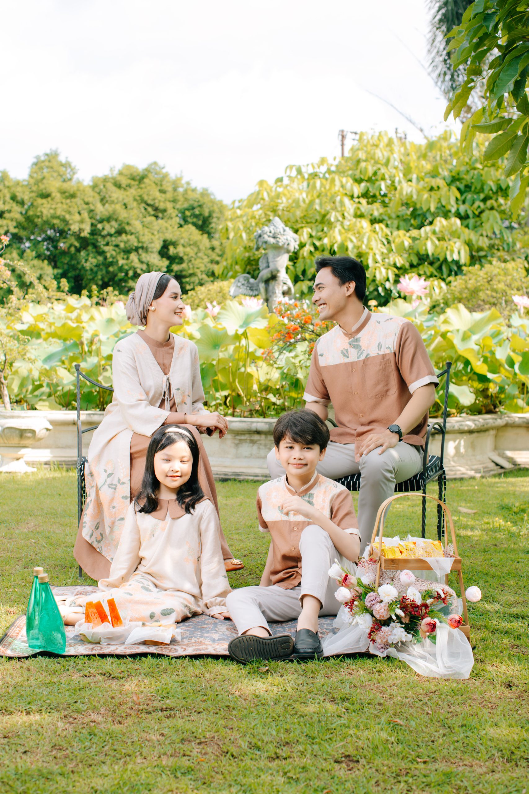 Model mengenakan koleksi Blooming Raya Series dari Batik Iskandartex dengan motif floral elegan di taman