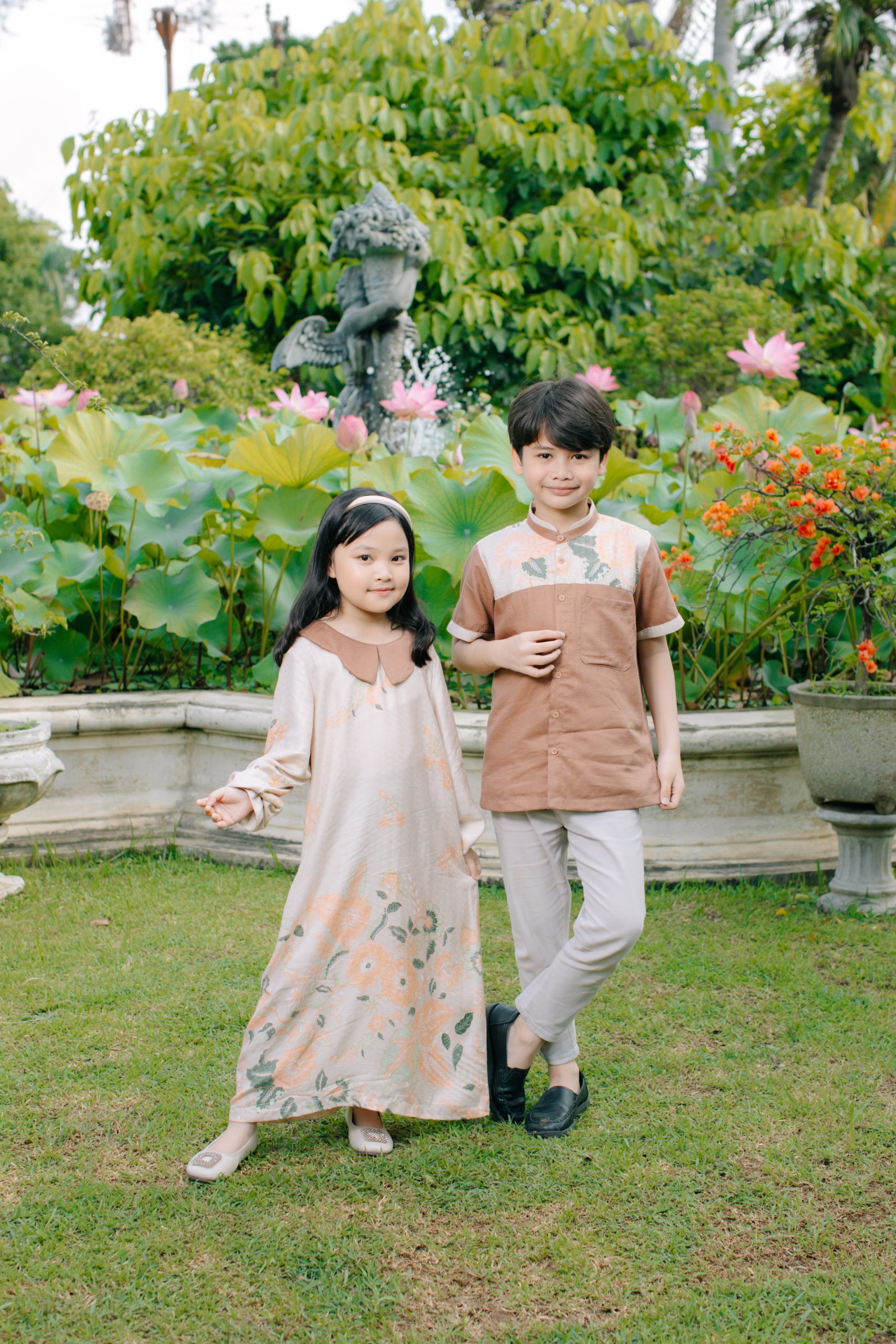 Model mengenakan koleksi Blooming Raya Series dari Batik Iskandartex dengan motif floral elegan di taman