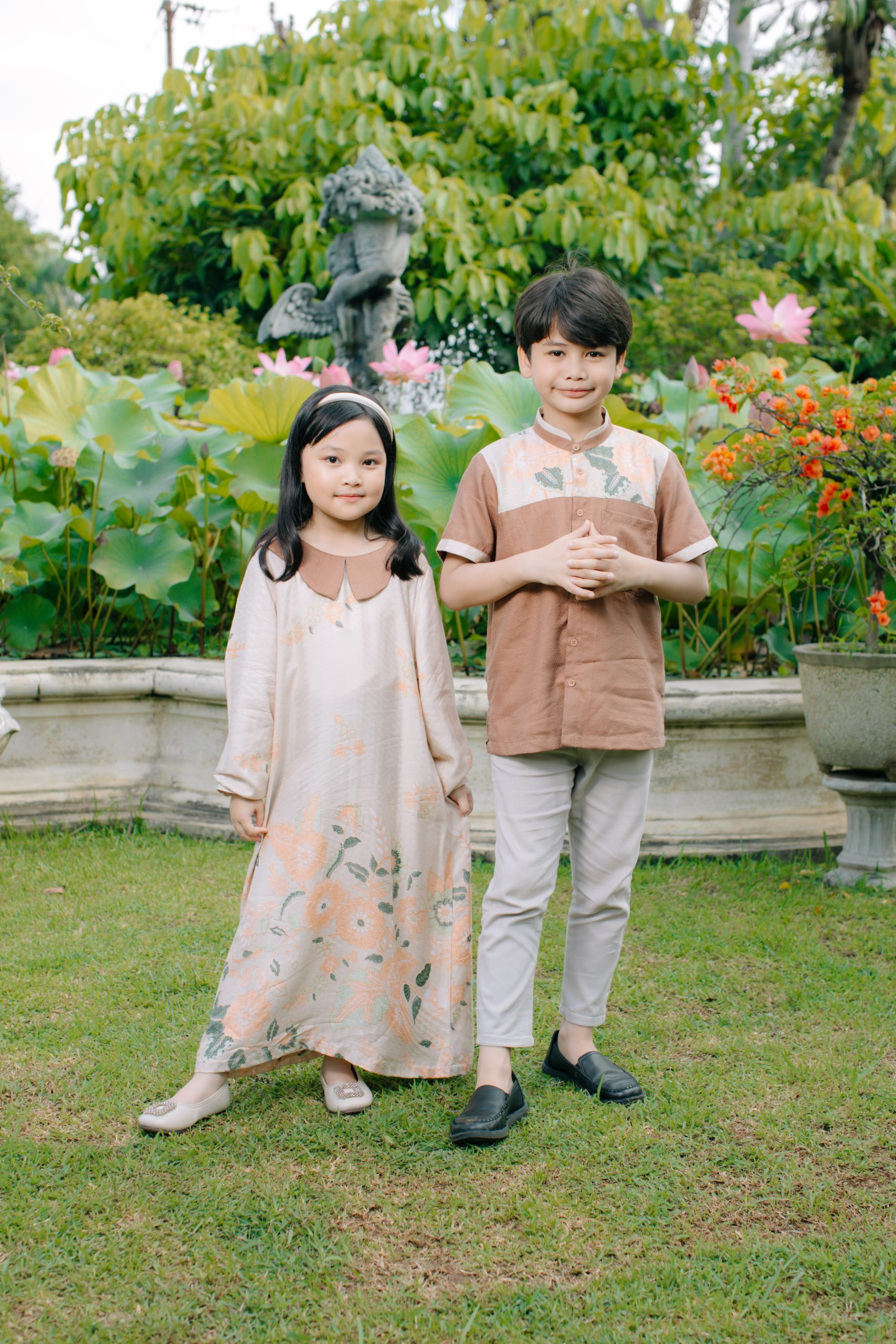 Model mengenakan koleksi Blooming Raya Series dari Batik Iskandartex dengan motif floral elegan di taman