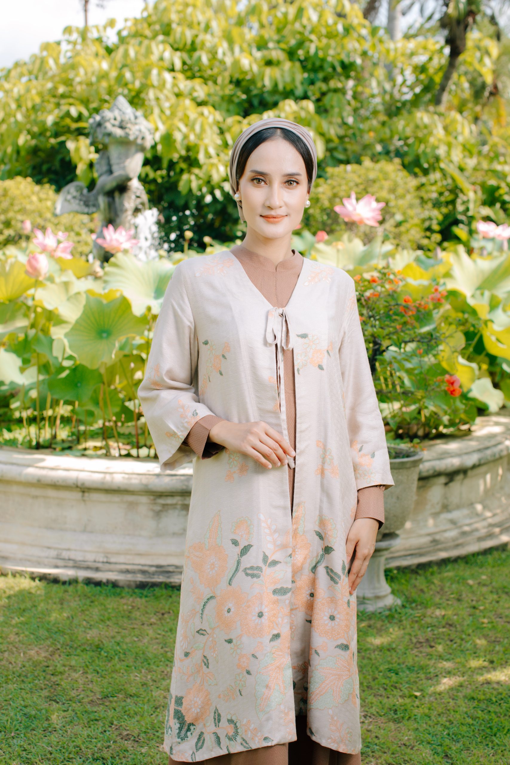 Model mengenakan koleksi Blooming Raya Series dari Batik Iskandartex dengan motif floral elegan di taman