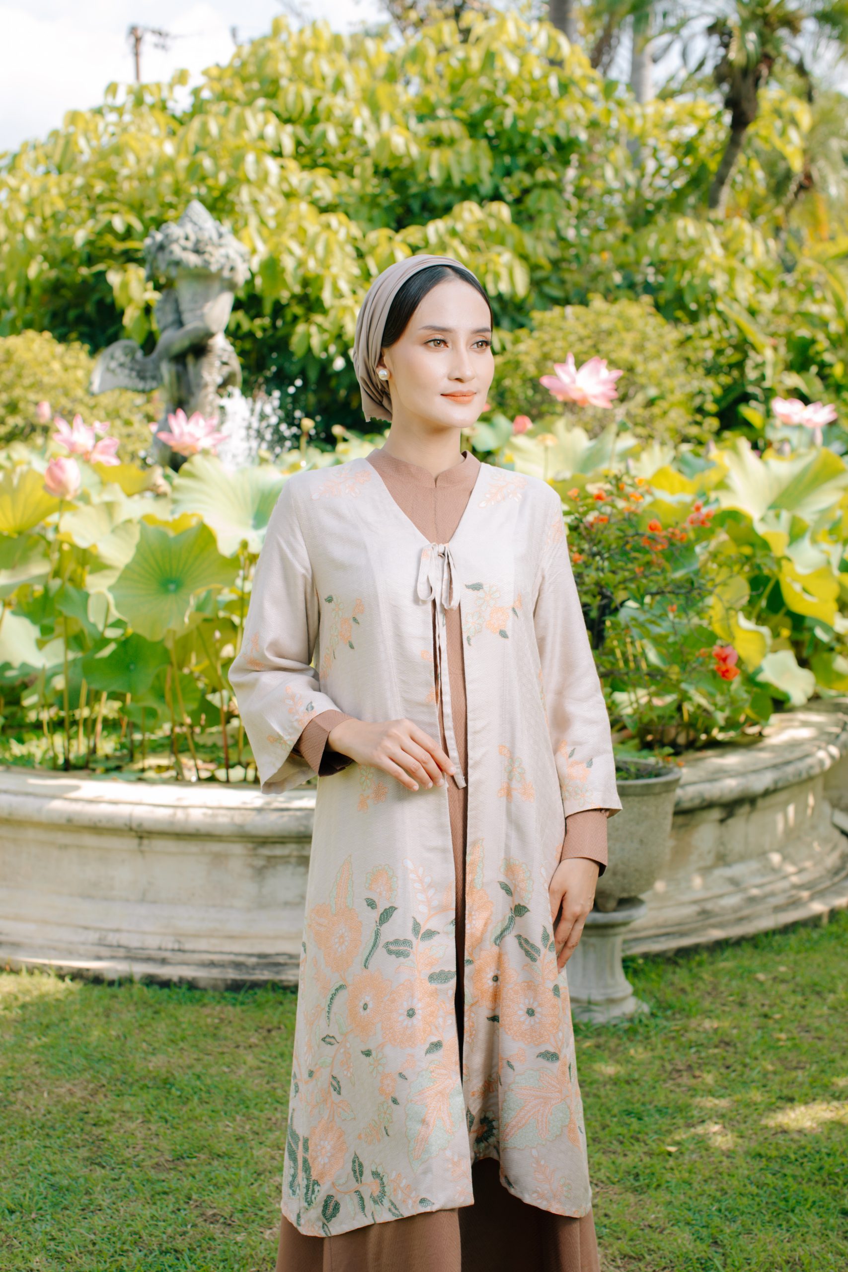 Model mengenakan koleksi Blooming Raya Series dari Batik Iskandartex dengan motif floral elegan di taman