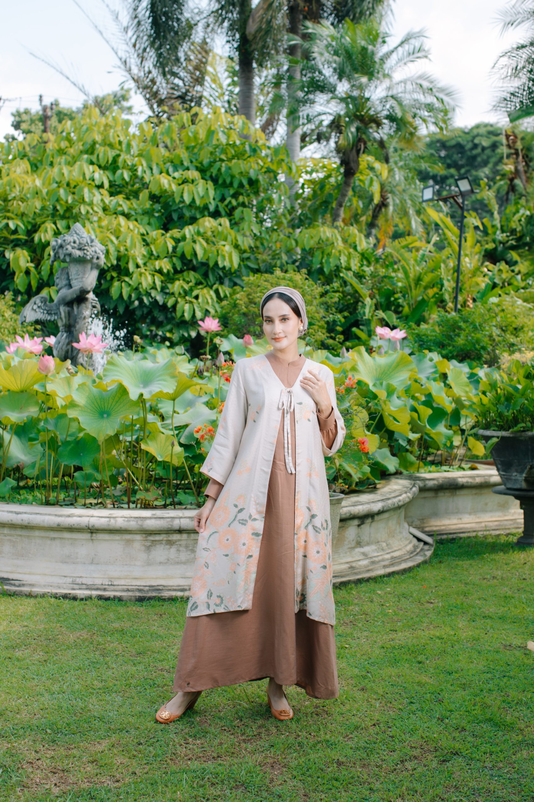 Model mengenakan koleksi Blooming Raya Series dari Batik Iskandartex dengan motif floral elegan di taman