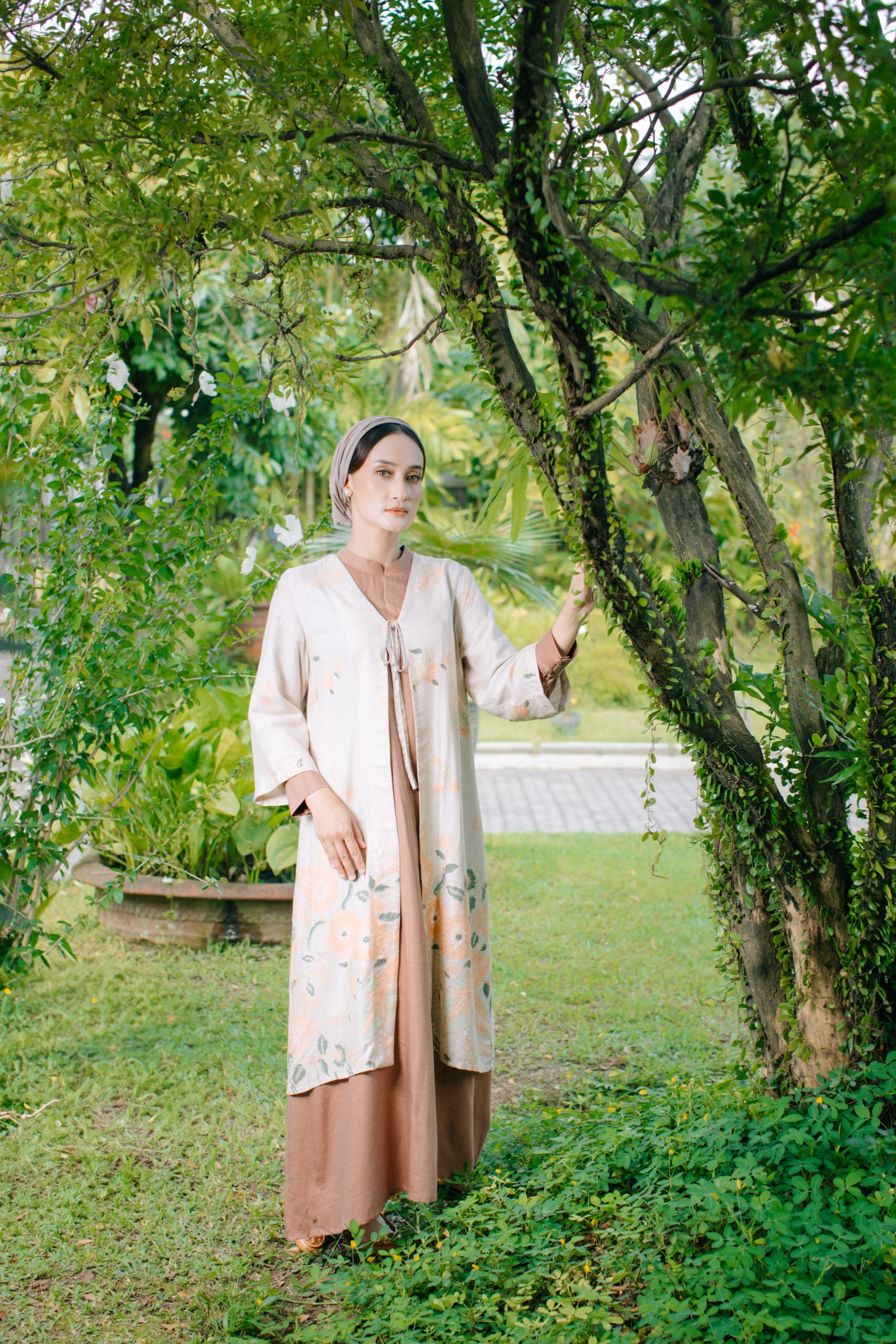 Model mengenakan koleksi Blooming Raya Series dari Batik Iskandartex dengan motif floral elegan di taman