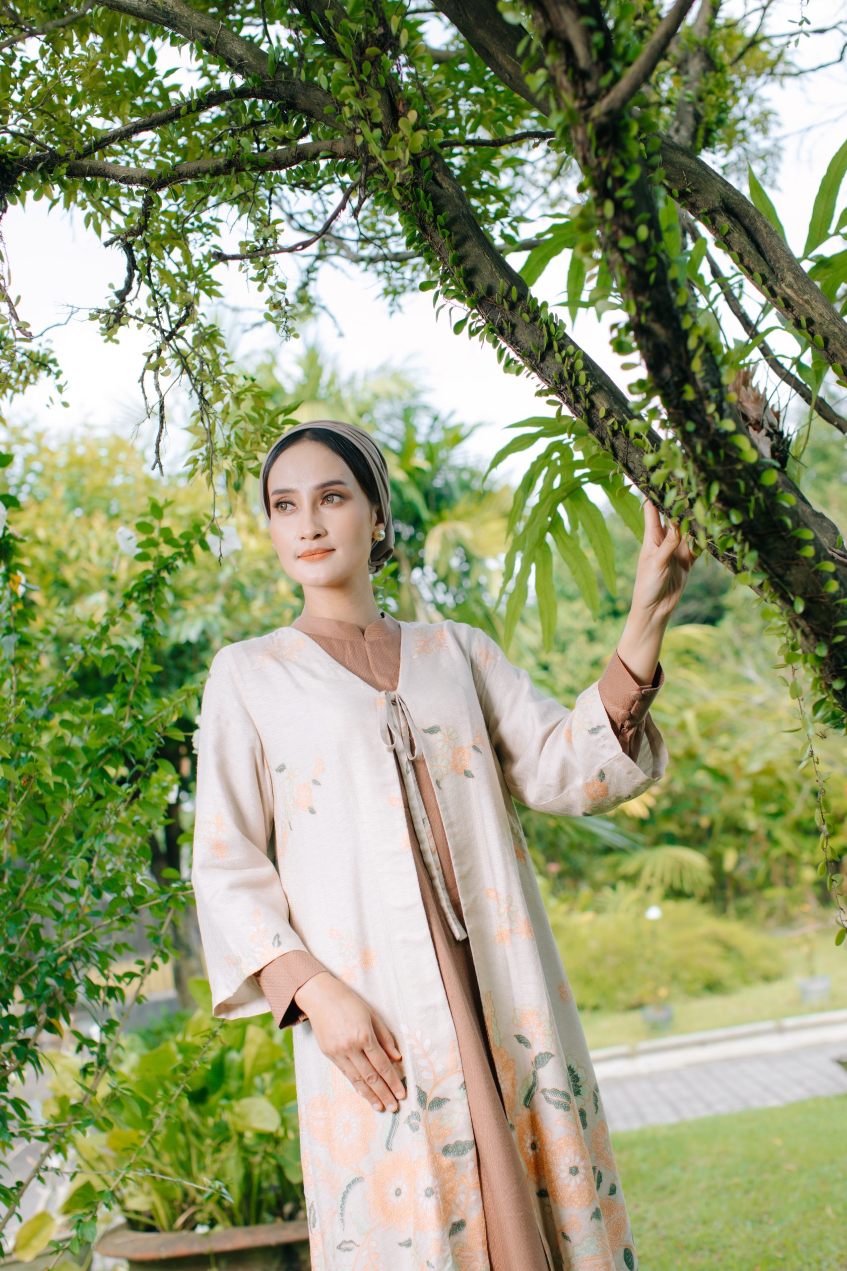 Model mengenakan koleksi Blooming Raya Series dari Batik Iskandartex dengan motif floral elegan di taman